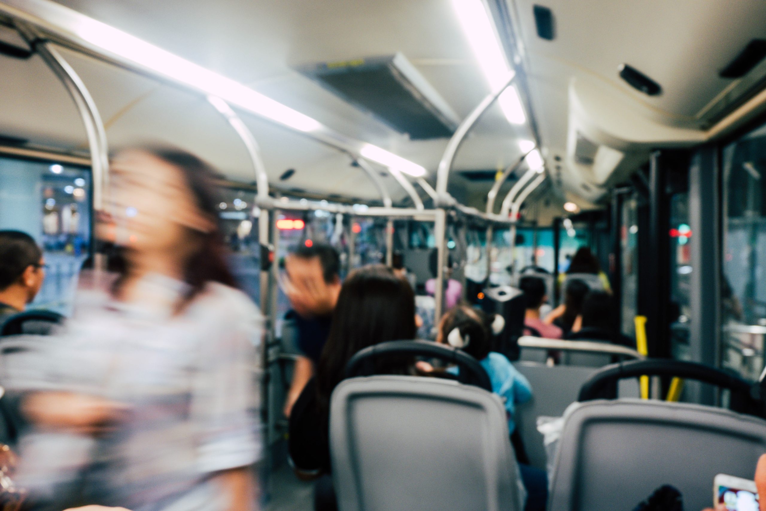 Blurred passenger moving through a crowded bus